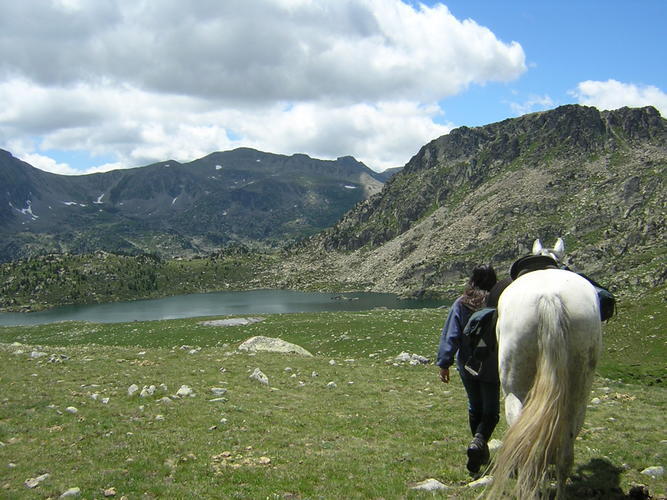 Ruta a cavall vora un estany d'alta muntanya